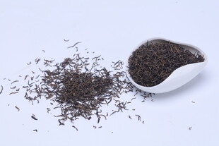 白瓷勺中的散装黑茶叶