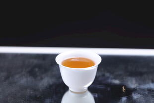 白瓷小杯盛金黄茶汤