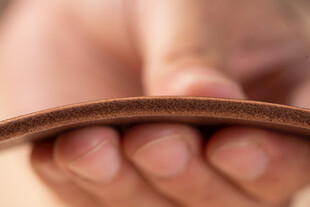 双手持握棕色皮革制品