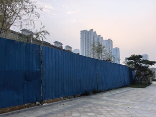 蓝色围挡旁的城市景象