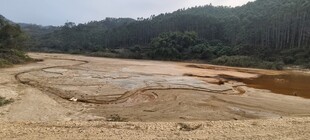 泥泞荒地周边山林环绕