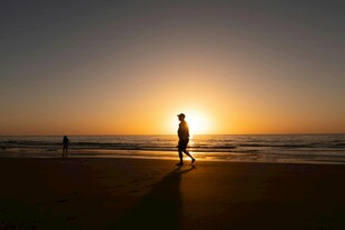夕阳下海滩上的孤独身影