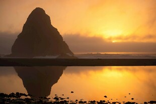 夕阳下的孤峰与平静湖面