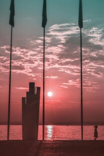 海边日落时的旗杆剪影