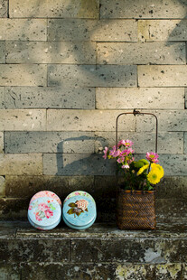 复古风墙面旁的花卉与瓷盘