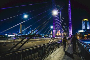 城市桥梁夜景下的行人漫步