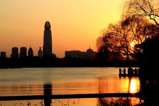 湖畔夕阳下的城市天际线