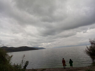 湖畔阴云下的两人漫步