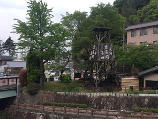 日本河畔古朴水车与绿树建筑