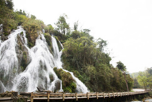 荔波山间瀑布下的木质栈道