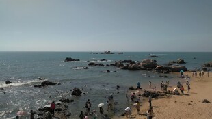 三亚海边沙滩人群与礁石景观