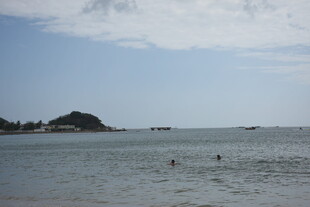 三亚海边风光 远处小岛与戏水者