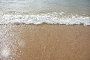 三亚海浪轻拍沙滩的美丽瞬间