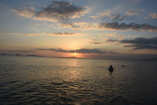 三亚海上日落时的孤舟美景