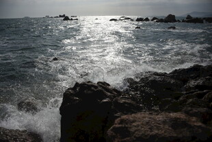 三亚海边礁石旁的汹涌海浪