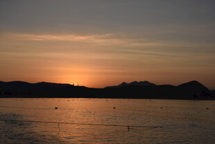 三亚夕阳下的宁静水面与远山