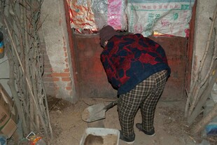 老人在狭窄空间俯身劳作