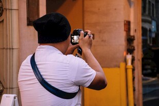 男子街头专注拍照瞬间