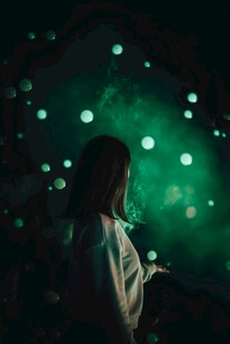 女孩置身梦幻绿光点场景