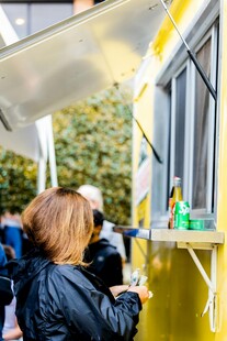 女子在黄色餐车前购买食物