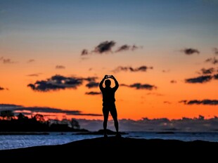 夕阳下的海边瑜伽者