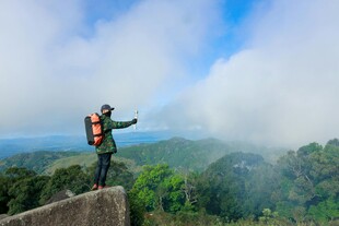 背包客山顶赏景展双臂