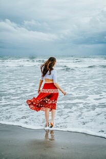 海边红衣女子漫步赏景