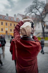街头红衣男子专注拍照