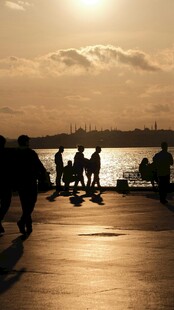 夕阳下的海边人群剪影