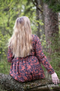 林中女子倚坐树干背影