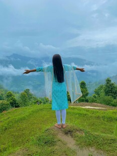 女子于山间舒展双臂赏景