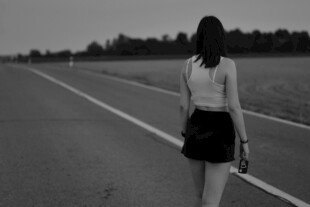 女孩独行于空旷道路