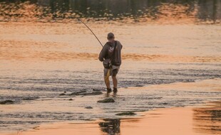 夕阳下的河畔垂钓者