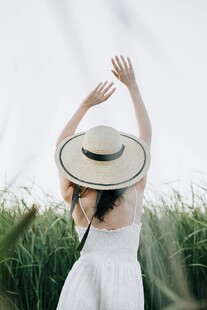 白衣女子于草地优雅举臂