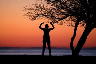 夕阳下海边的伸展身影