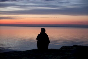 夕阳下独赏湖景的身影