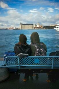 两人坐长椅赏海景