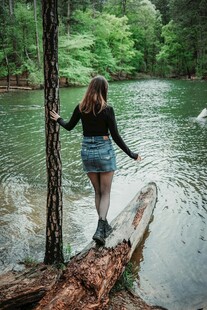 女子立于林间浮木赏景