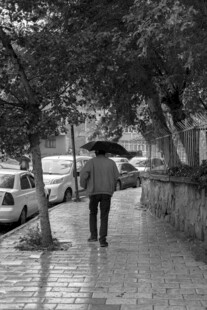 雨中撑伞独自行走的人