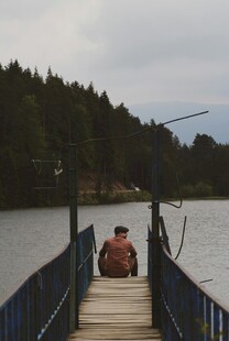 湖畔栈桥独坐的钓鱼者