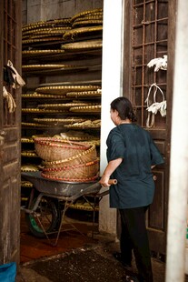 妇女搬运竹制品于作坊门口