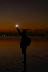 黄昏湖畔独行者举灯远望