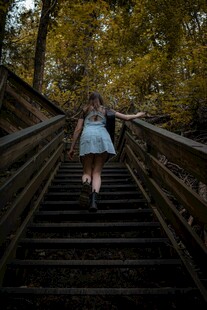 女孩漫步于林间木质阶梯