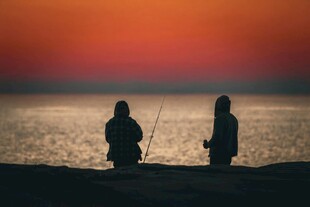 夕阳下两人海边垂钓