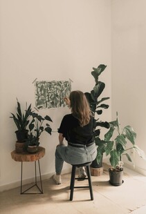 女子专注于室内绿植绘画