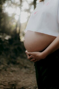 孕妇户外轻抚隆起的腹部