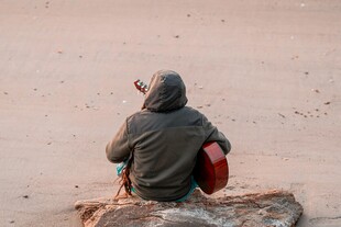 孤独旅人坐于石上望远方