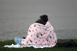 裹毛毯坐岸边的孤独身影