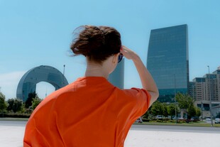 红衣女子眺望城市建筑