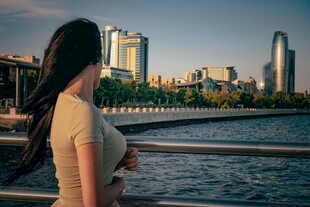 女子河畔眺望城市天际线